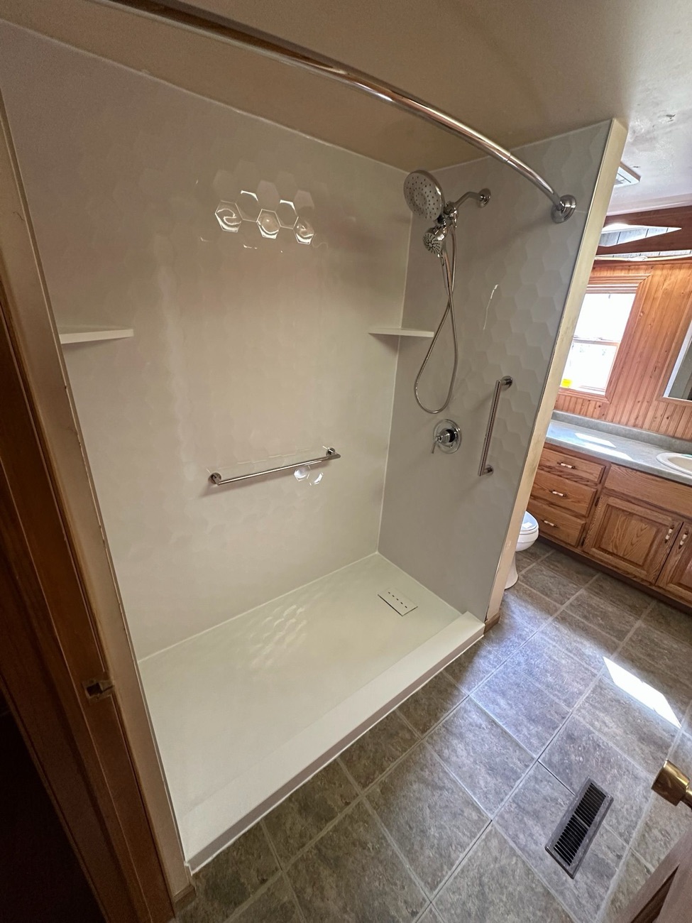 White low threshold shower with grab bar installed by American Shower Company